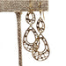 Vintage 10kt yellow gold filigree dangle earrings displayed on a fabric stand