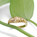 Vintage 18kt yellow gold diamond ring resting on green leaf