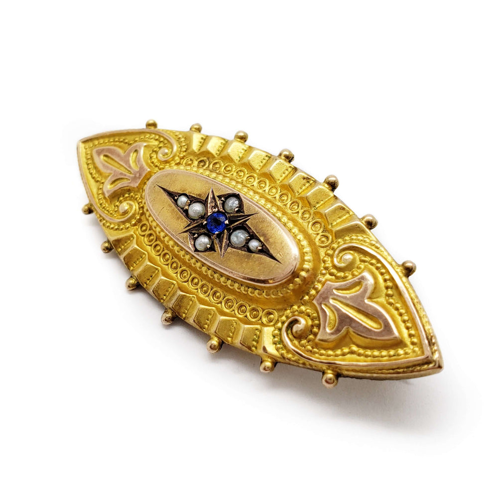 Detailed view of vintage 9k gold mourning pin with seed pearls and blue stone