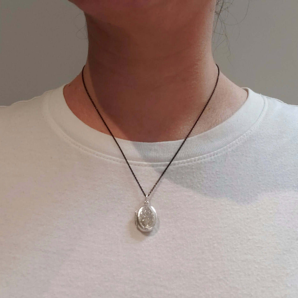 Vintage sterling silver oval locket necklace worn on a model