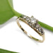 Vintage diamond ring in 14kt yellow and white gold with transitional and single cut diamonds, shown on white background with green leaf