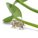Vintage diamond starburst earrings in 14kt yellow and white gold displayed with green leaf