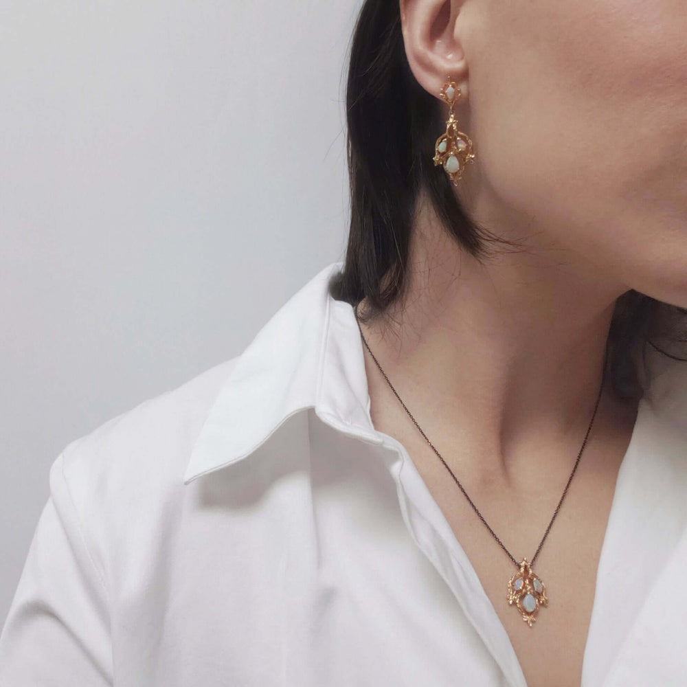 Model wearing vintage 14kt yellow gold opal twig earring and matching pendant