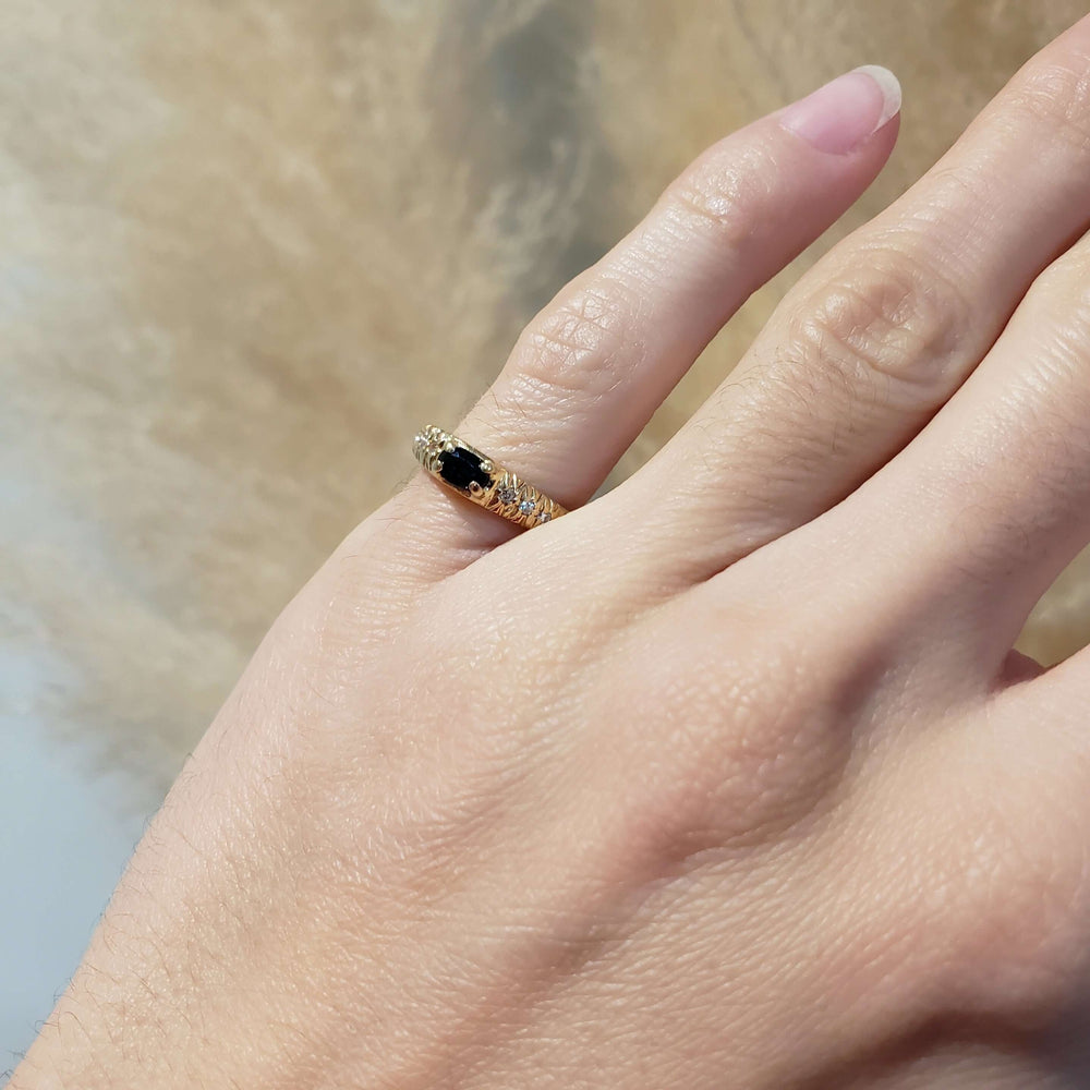 Vintage sapphire and diamond pinky ring in yellow gold shown on a hand