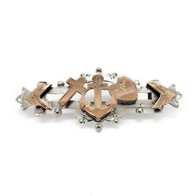 Front view of vintage silver and rose gold pin with cross, anchor, and heart motif