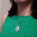 Vintage sterling silver engraved oval locket worn on a model