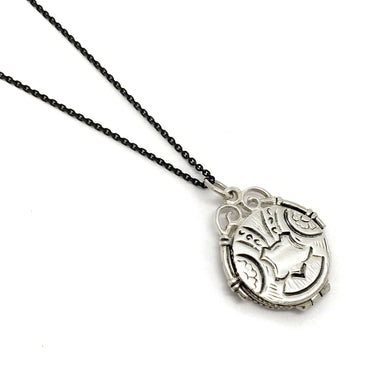 Vintage sterling silver round locket with ornate engraving on a black chain