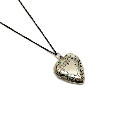 Vintage sterling silver heart locket with floral enamel detail on a black chain