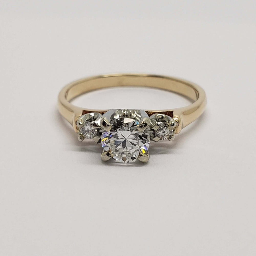 Vintage three-stone diamond engagement ring with central and side diamonds, front view