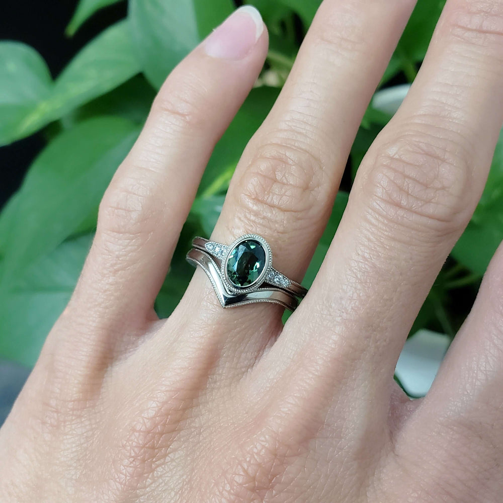 White gold Australian sapphire and diamond ring paired with two stacking bands, worn on a hand