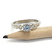 White gold ring with blue Montana sapphire and two diamonds, shown beside a pencil