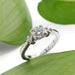 White gold antique diamond engagement ring displayed on green leaves