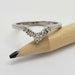 White gold chevron wedding ring with diamonds shown next to a pencil