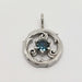 Close-up of a white gold circle vine pendant with a round blue sapphire.