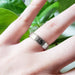 Textured white gold wedding band worn on hand, close-up