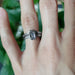 White gold emerald cut lab diamond engagement ring stacked with chevron wedding band, on hand
