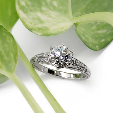 White gold engagement ring with round moissanite and diamond accents, vintage millgrain detail