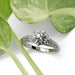 White gold engagement ring with round moissanite and diamond accents, vintage millgrain detail
