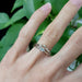 White gold marquise lab diamond ring stacked with curved diamond band on hand