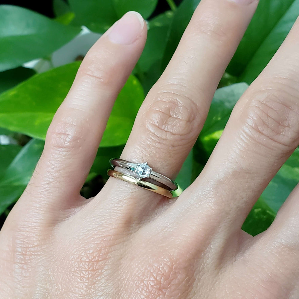 White gold rose cut diamond engagement ring stacked with yellow gold band on hand