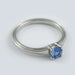 Handcrafted white gold ring with round blue sapphire and millgrain edge, solitaire setting
