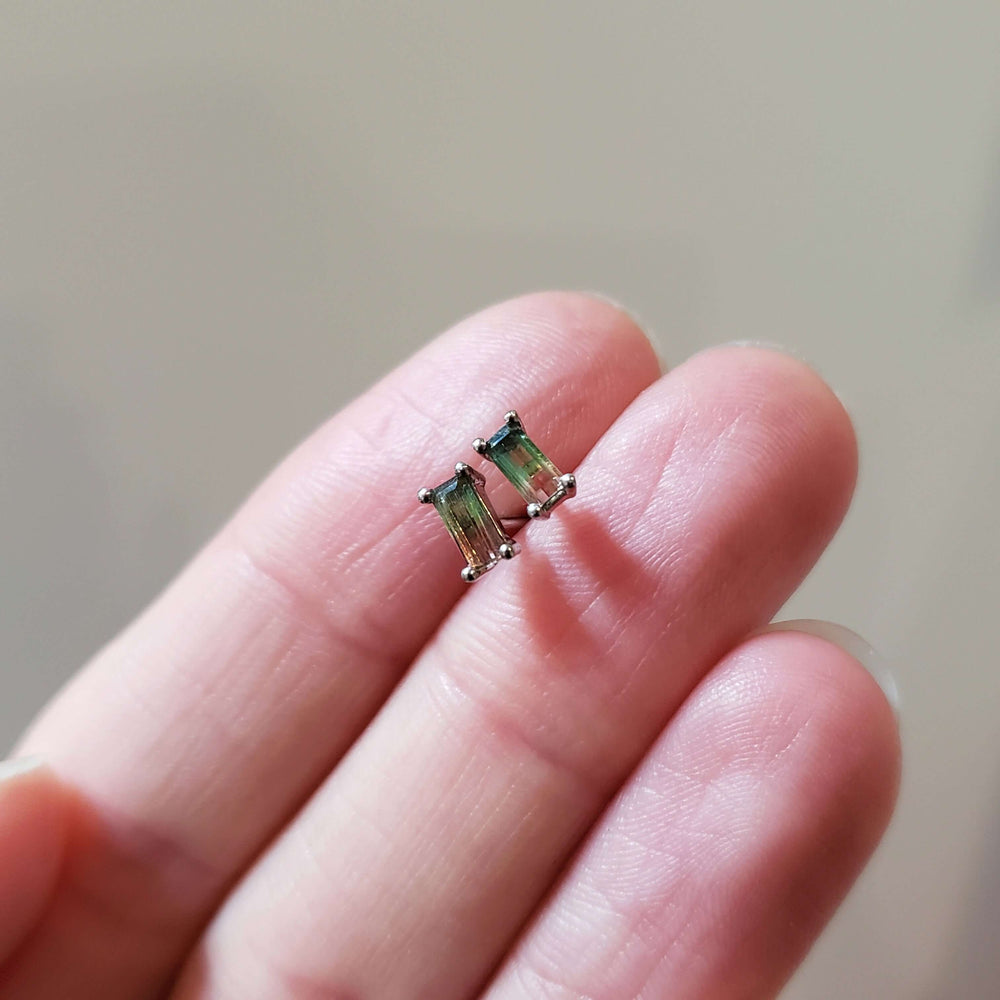 Baguette watermelon tourmaline stud earrings in white gold shown on a hand