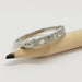 White gold wedding ring with Canadian diamonds and hand engraving, displayed on a pencil