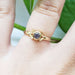 Yellow gold Montana sapphire engagement ring with leaf details, shown on hand