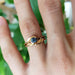 Yellow gold Montana sapphire leaf ring stacked with a band on a hand