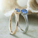 Two solitaire engagement rings with blue sapphires, one in yellow gold and one in white gold