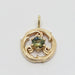 Close-up of a yellow gold circle vine pendant with a round bi-colour sapphire.