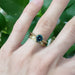 Yellow gold engraved diamond wedding band stacked with blue gemstone ring on hand