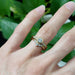 Yellow gold lab diamond engagement ring stacked with chevron diamond band, worn on hand