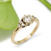 Handcrafted yellow gold engagement ring with lab-grown diamond and accent stones, leaf background