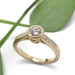 Yellow gold lab diamond engagement ring with engraved details, shown on white with leaf