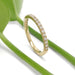 Yellow gold lab diamond wedding ring displayed with green leaves