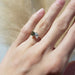 Yellow gold moi et toi ring with diamond and teal sapphire shown on hand