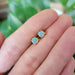 5mm opal stud earrings in yellow gold shown on a hand