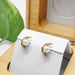 Pearl moon stud earrings in yellow gold displayed in a wooden jewellery box