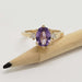 Front view of yellow gold ring with oval lavender sapphire and two lab grown diamonds