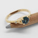 Yellow gold ring with teal Montana sapphire and bezel-set Canadian diamonds on a pencil