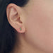 Watermelon tourmaline baguette stud earring in yellow gold worn on an ear